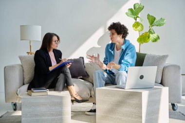 Zihinsel terapi seansı, kadın psikolog, terapist, sosyal hizmet görevlisi ile konuşan genç adam ofiste birlikte oturuyor. Psikoloji Psikiyatri Danışmanlık Destek Gençlere Yardım