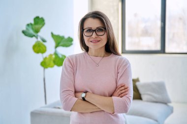 Kendine güveni tam, olgun, güzel bir kadın çapraz kollarla kameraya bakıyor. İş, iş, başarı, güven, olgun insanlar konsepti