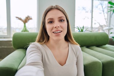 Selfie portresi. Mutlu, genç ve güzel bir kadın. Kameraya bakan 20 'li yaşlarda, uzun sarı saçlı ve gülümseyen çekici bir kadın. Güzellik mutluluğu eğlence yaşam tarzı konsepti