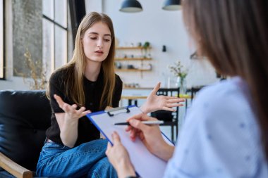 Sosyal hizmet görevlisiyle konuşan genç bir kadın, ev toplantısı, psikolojik danışmanın ev ziyareti, araştırma danışmanlığı. Sosyal hizmetler, psikoloji psikoterapisi tedavi desteği, akıl sağlığı, gençlik