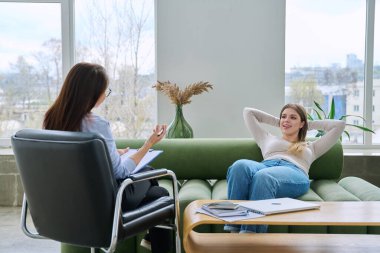 Terapi seansında psikolog terapist muayenehanesinde kanepede uzanan rahat genç bir kadın. Psikoloji, psikoterapi, danışmanlık, tedavi, gençlik için zihinsel sosyal psikolojik hizmet