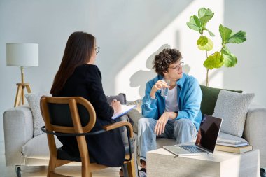 Akıl hastanesindeki genç adam profesyonel psikologla konuşuyor. Hasta ile çalışan kadın psikiyatrist danışmanı. Psikoloji psikiyatri tedavi desteği gençlere yardımcı oluyor