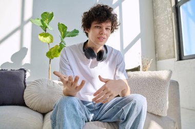 Webcam görüntüsü, genç üniversite öğrencisinin web kamerasına bakması, online görüşme, internet görüntülü sohbet konferansı. Kıvırcık saçlı yakışıklı erkek blogger vlogger kayıt videosu evde