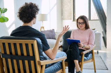 Orta yaşlı kadın psikolog psikoterapist terapist genç erkek hasta ile çalışan zihinsel terapist. Psikoloji psikoterapi sosyal sağlık hizmetleri tedavi destek konsepti