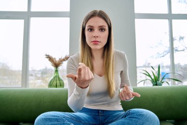 Web kamerasında genç, güzel, ciddi bir kadının internette sohbet konferansı hakkında konuşurken görüntüsü var. Çekici kadın blogger vlog kaydedici ev kumandasında video kaydediyor