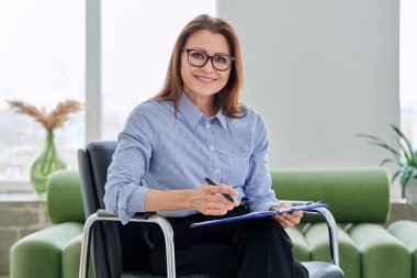 Ofisteki kameraya bakan profesyonel psikolog sosyal hizmet görevlisi kadın portresi. Psikoloji, psikoterapi, danışmanlık, tedavi, ruh sağlığı hizmetleri