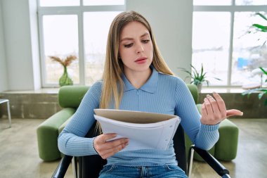 Webcam görüntüsü, ders kitabı olan genç bir kız öğrenci koltuğunda oturmuş eğitim amaçlı webinar eğitim blogu kaydetmek için çevrimiçi toplantı görüntülü konferans görüşmesi yapıyor. Teknoloji eğitimi e-öğrenimi