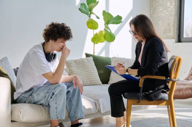 Üzgün üzgün, terapi seansındaki genç erkek hasta psikolog danışmanlık ofisinde. Ruh sağlığı, psikoloji psikoterapisi, sosyal hizmetler, tedavi desteği gençlik kavramına yardım