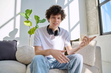 Webcam görüntüsü, genç üniversite öğrencisinin web kamerasına bakması, online görüşme, internet görüntülü sohbet konferansı. Kıvırcık saçlı yakışıklı erkek blogger vlogger kayıt videosu evde