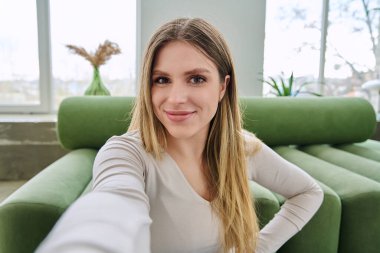 Selfie portresi. Mutlu, genç ve güzel bir kadın. Kameraya bakan 20 'li yaşlarda, uzun sarı saçlı ve gülümseyen çekici bir kadın. Güzellik mutluluğu eğlence yaşam tarzı konsepti