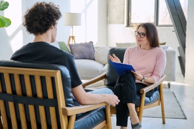 Orta yaşlı kadın psikolog psikoterapist terapist genç erkek hasta ile çalışan zihinsel terapist. Psikoloji psikoterapi sosyal sağlık hizmetleri tedavi destek konsepti