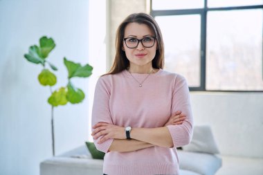 Kendine güveni tam, olgun, güzel bir kadın çapraz kollarla kameraya bakıyor. İş, iş, başarı, güven, olgun insanlar konsepti