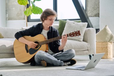 Akustik gitar dizüstü bilgisayarı olan genç bir çocuk, çevrimiçi müzik dersi alıyor, müzik blogu vlog 'u kaydediyor, takipçilerle iletişim kuran genç bir nüfuzlu. Yaşam tarzı ergenlik eğitimi teknolojisi kavramı