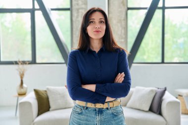 Ofiste kendine güvenen güzel bir kadının portresi. Kollarını kavuşturup kameraya bakan gülümseyen bir kadın. Güzellik, yaşam tarzı, sağlık, 30 'ların insan kavramı