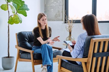 Psikolog terapistinin ofisinde ciddi bir genç kız. Genç bayan hasta psikoterapist sosyal uzmanıyla konuşuyor. Psikoloji psikoterapi zihinsel hizmetleri
