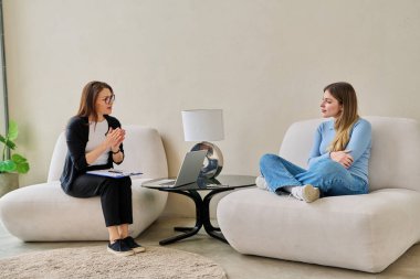 Zihinsel terapi seansında gülümseyen genç bir kadın profesyonel psikolog psikoterapist danışmanıyla konuşuyor. Sosyal hizmetler, tedavi psikoloji psikoterapi sağlığına yardım