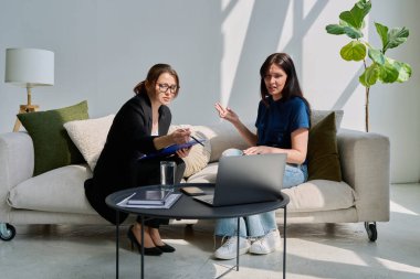 Zihinsel terapi seansında psikolog psikoterapist danışmanıyla konuşan genç bir bayan hasta. Sosyal destek hizmetleri, bireysel toplantılar, profesyonel psikolojik yardım