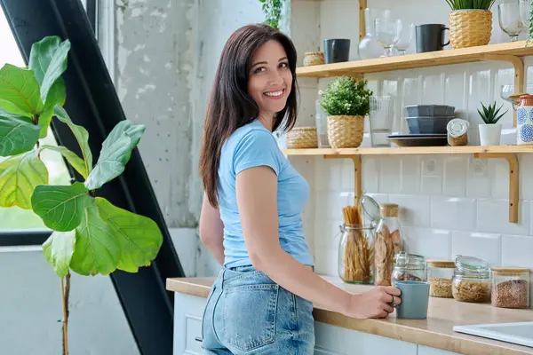 Mutfaktaki mutlu 30 'lu yaşlardaki güzel kadının portresi. Yaşam tarzı, ev hayatı, insan kavramı.