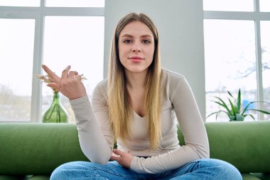 Web kamerasında genç ve güzel bir kadının kameraya, internet toplantısına ve sohbet konferansına baktığı görülüyor. Çekici kadın blogger vlog kaydedici evde video, uzaktan iletişim