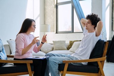 Üzgün üzgün, terapi seansındaki genç erkek hasta psikolog danışmanlık ofisinde. Ruh sağlığı, psikoloji psikoterapisi, sosyal hizmetler, tedavi desteği gençlik kavramına yardım