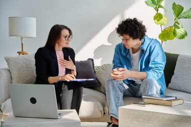 Zihinsel terapi seansı, kadın psikolog, terapist, sosyal hizmet görevlisi ile konuşan genç adam ofiste birlikte oturuyor. Psikoloji Psikiyatri Danışmanlık Destek Gençlere Yardım