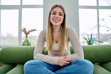 Web kamerasında genç ve güzel bir kadının kameraya, internet toplantısına ve sohbet konferansına baktığı görülüyor. Çekici kadın blogger vlog kaydedici evde video, uzaktan iletişim