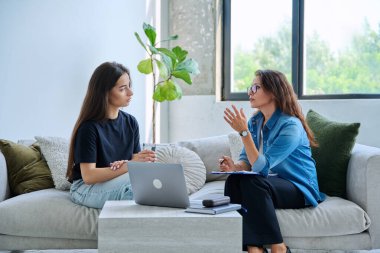 Psikolog terapistinin ofisinde ciddi bir genç kız. Genç bayan hasta psikoterapist sosyal uzmanıyla konuşuyor. Psikoloji psikoterapi zihinsel hizmetleri