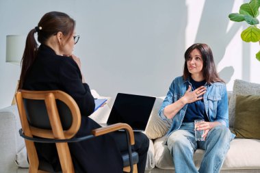 Zihinsel terapi seansında psikolog psikoterapist danışmanıyla konuşan genç bir bayan hasta. Sosyal destek hizmetleri, bireysel toplantılar, profesyonel psikolojik yardım