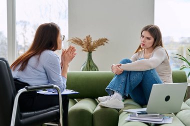 Üzgün üzgün, terapi seansında psikolog psikolog muayenehanesindeki genç kadın hasta. Ruh sağlığı, psikoloji psikoterapisi, sosyal hizmetler, tedavi desteği gençlik kavramına yardım