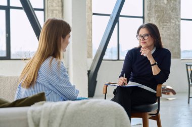 Profesyonel kadın terapist psikolog genç bir kadın hastayla çalışıyor. Psikoloji psikoterapi zihinsel terapi seansı, gençlik öğrencileri için sosyal psikolojik hizmet