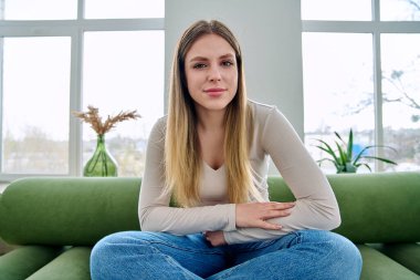 Web kamerasında genç ve güzel bir kadının kameraya, internet toplantısına ve sohbet konferansına baktığı görülüyor. Çekici kadın blogger vlog kaydedici evde video, uzaktan iletişim