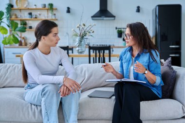 Psikolog terapistinin ofisinde ciddi bir genç kız. Genç bayan hasta psikoterapist sosyal uzmanıyla konuşuyor. Psikoloji psikoterapi zihinsel hizmetleri