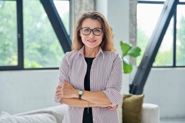 Siyah takım elbiseli, kameraya bakan orta yaşlı bir iş kadınının portresi. Ofiste çapraz kollu 40 'lı yaşlarda kendinden emin bir kadın. İş yönetimi kariyeri olgun insanlar