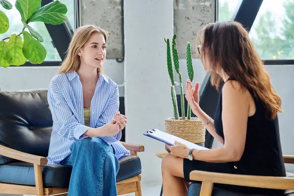 Psikoloji seansında genç bir kadın profesyonel terapist ve akıl uzmanıyla konuşuyor. Terapi, psikoterapi, danışmanlık, gençlere yönelik sosyal hizmetler