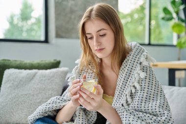 Genç bir kadın kendini bir fincan sıcak çayla limonla ısıtıyor. Yazın yüksek sıcaklıkta viral enfeksiyon kapıyor. Mevsimsel viral hastalıklar, hastalık, tedavi, sağlık gençliği kavramı