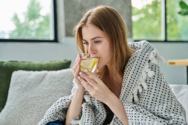 Genç bir kadın kendini bir fincan sıcak çayla limonla ısıtıyor. Yazın yüksek sıcaklıkta viral enfeksiyon kapıyor. Mevsimsel viral hastalıklar, hastalık, tedavi, sağlık gençliği kavramı