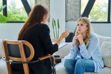 Ofisteki genç bayan hasta kadın psikolog psikolog psikoterapist psikologla konuşuyor. Psikoloji psikoterapi tedavisi hizmet kavramını desteklemeye yardımcı olur