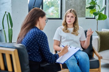 Ofisteki genç bayan hasta kadın psikolog psikolog psikoterapist psikologla konuşuyor. Psikoloji psikoterapi tedavisi hizmet kavramını desteklemeye yardımcı olur