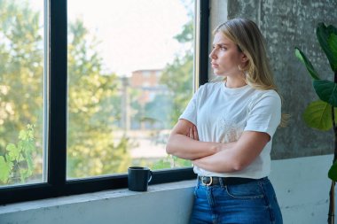 Mutsuz genç kadın pencereden dışarı bakıyor, profil görüntüsü, kopyalama alanı. Duygusal acı çeken üzgün bir kadın. Sorunlar, zorluklar, gençlik, yaşam tarzı konsepti