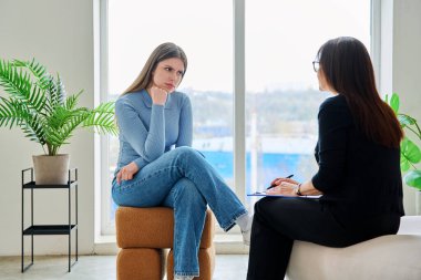 Terapi seansında psikoterapist psikolog psikanalist sosyal hizmet uzmanıyla konuşan genç bir kadın. Ruh sağlığı, profesyonel psikolojik danışmanlık, gençlik öğrencileri için sosyal hizmetler