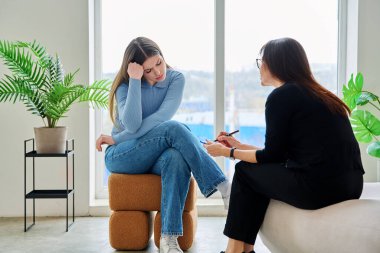 Terapi seansında psikoterapist psikolog psikanalist sosyal hizmet uzmanıyla konuşan genç bir kadın. Ruh sağlığı, profesyonel psikolojik danışmanlık, gençlik öğrencileri için sosyal hizmetler