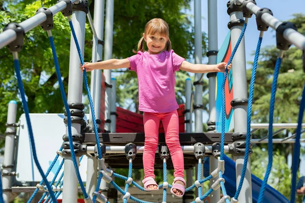 Little Cheerful Girl Walks Rope Bridge Playground Park — Stock Photo, Image