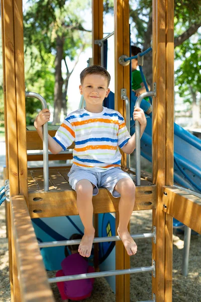 Ein Fröhlicher Junge Sitzt Oben Auf Einem Spielplatz Mit Rutschen — Stockfoto