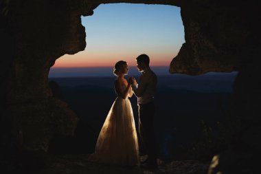 Ay ışığı dağlardaki gelin ve damadın siluetlerini vurgular.