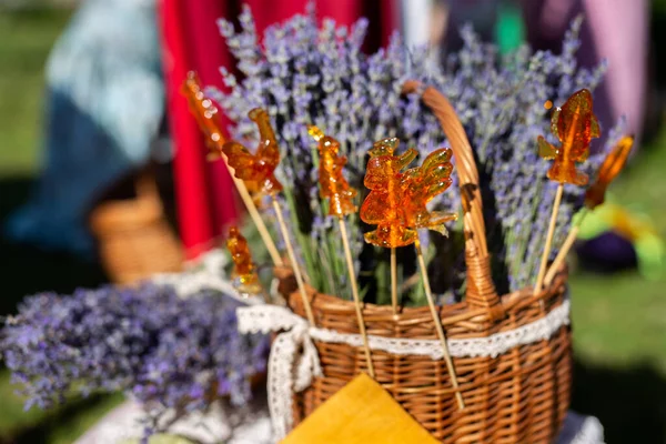 stock image Natural lollipop cockerel at the fair on the background of lavender