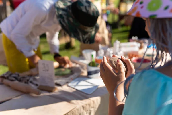 Stock image Hands of a child sculpt clay dishes at a fair