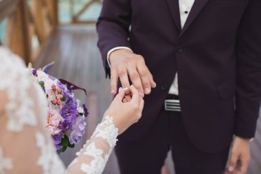 Gelin damadın parmağına yüzük takar.