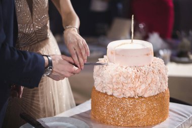 Gelin ve damat bir ziyafette muhteşem bir düğün pastası kesti.