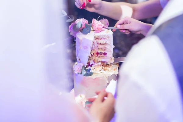 新娘和新郎在宴会上切了一个华丽的结婚蛋糕 — 图库照片