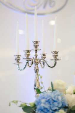 Wedding candle holder with floral decoration at the wedding banquet clipart